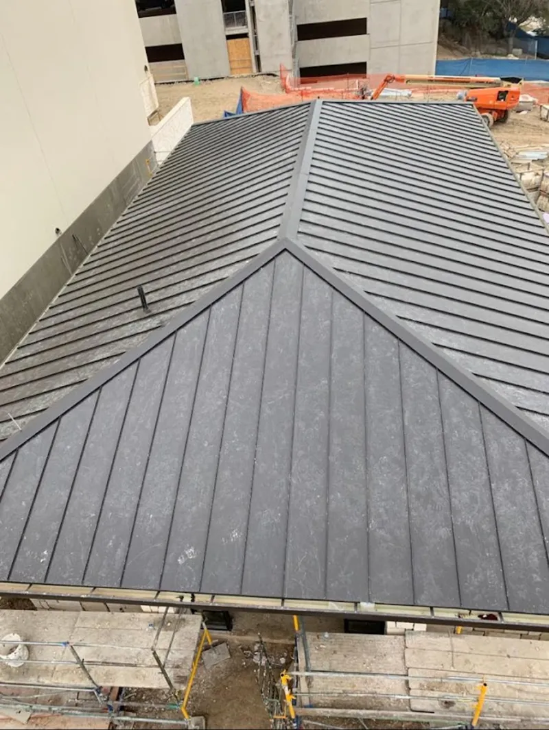 Commercial metal roof construction with crane equipment in Keyes