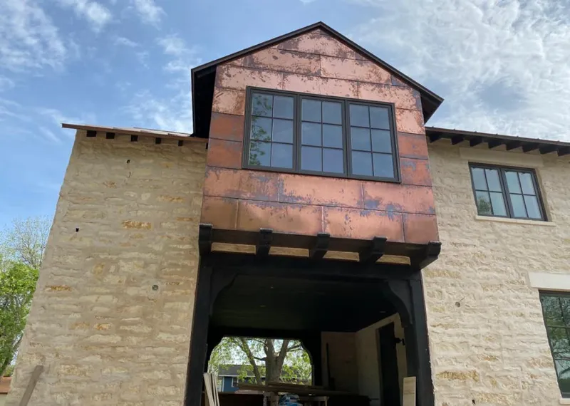 Copper metal panel facade on a stone building for Roof Repair in Keyes
